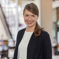 Porträt von Dörte Bachmann, Sustainability Managerin, stehend leicht schräg mit Hintergrund in einer Lobby 