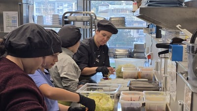 Köche bereiten Salate in der Restaurantküche zu.