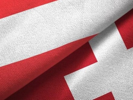 Übereinandergelegte rot-weisse Flaggen.