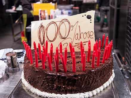 Eine Torte mit vielen roten Kerzen und einer Aufschrift zum hundertjährigen Jubiläum der SV Group.