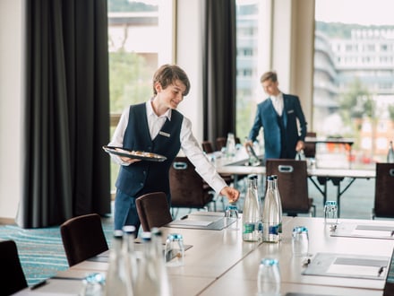 Hotelangestellte bereiten einen Konferenzraum vor.