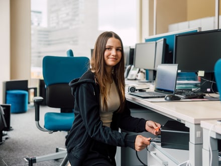 Frau, die in einem modernen Büro an einem Schreibtisch arbeitet.