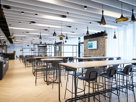 Ein einladendes und modernes Mitarbeiterrestaurant der SV Group in der Schweiz mit einem schönen Holzboden und vielen Fenstern, das viel Raum für Begegnung schafft.