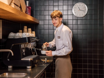 Barista bereitet Kaffee an der Kaffeemaschine zu.