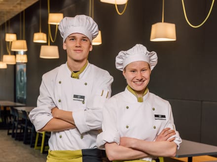 Zwei Köche in Uniformen stehen in einem Restaurant.
