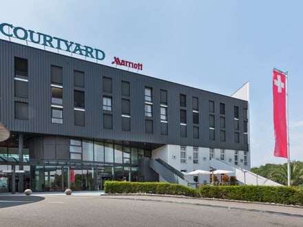 Courtyard by Marriott Hotelgebäude mit Schweizer Flagge.