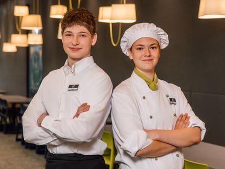 Zwei Mitarbeiter in Uniformen stehen in einem Restaurant.