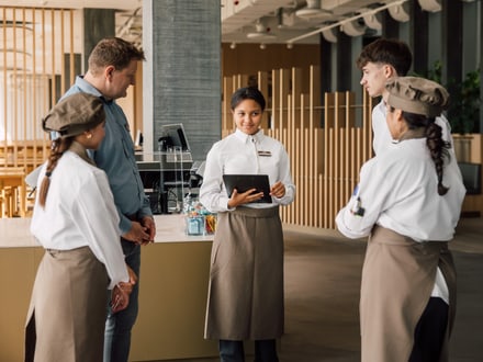 Gruppe von Kellnern und Kellnerinnen im Gespräch in einem Restaurant.