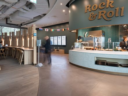 Moderne Cafeteria mit Theke und dekorativer Beleuchtung.