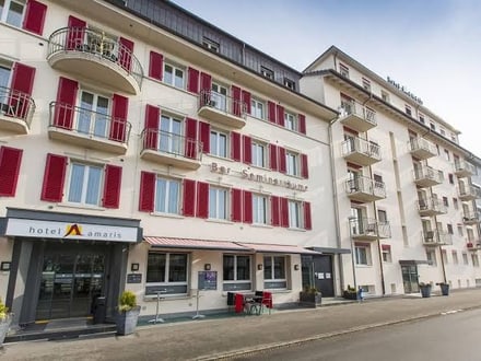 Aussenansicht des Hotels Amaris mit roten Fensterläden.",