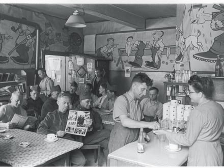 Historisches Bild von einem Personalrestaurant, wo Soldaten an den Tischen sitzen und sich verpflegen.