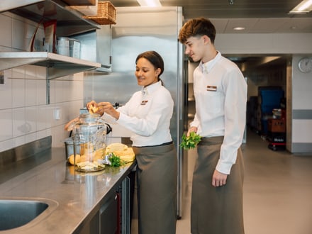 Zwei Systemgastronomiefachleute in der Küche, bereiten Zutaten vor.