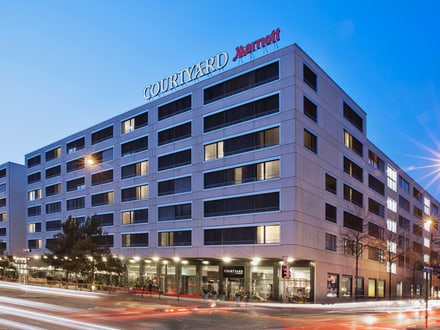 Courtyard Marriott Hotelgebäude bei Nacht mit Strassenlichtern.