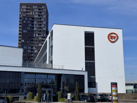 Moderne Gebäude mit SV-Logo und Autos davor.
