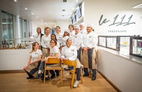 Restaurantteam von Le 111 posiert in Uniformen.