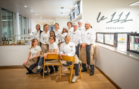 Restaurantteam von Le 111 posiert in Uniformen.