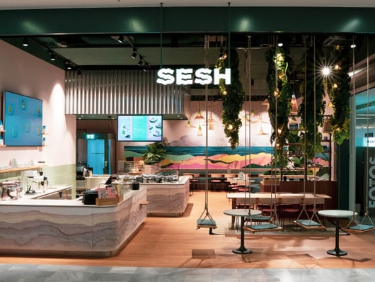 Essbereich im Restaurant Sesh mit leuchtender Reklame von Sesh 