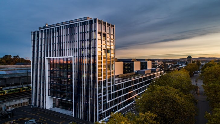 Moderne Bürogebäude in einer städtischen Umgebung bei Sonnenuntergang.
