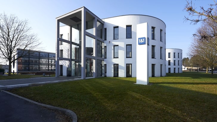 Modernes Bürogebäude bei Tageslicht mit grossen Fenstern.