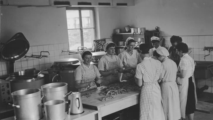 Historisches Bild von Frauen in der Küche, die Bohnen schneiden.