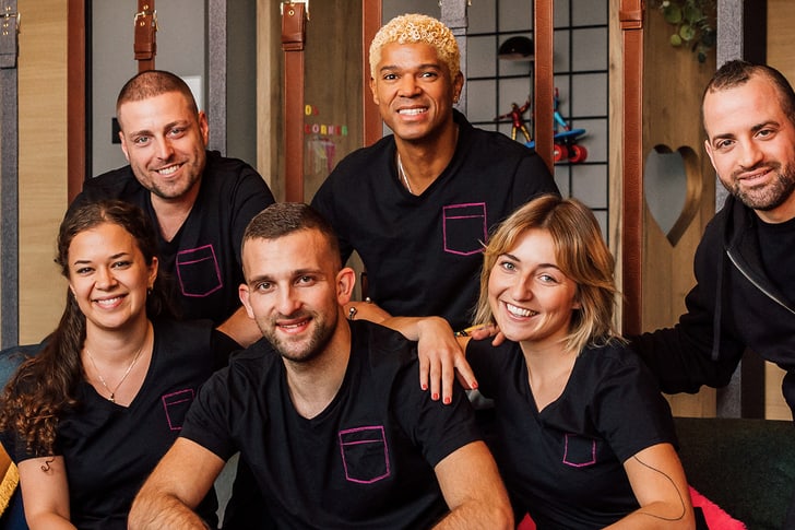 Gruppe von Menschen in schwarzen Hemden lächelnd auf Sofa.