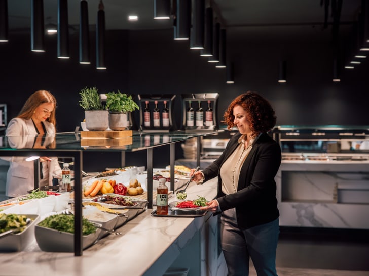 Zwei Frauen an einem modernen Buffet in einem Restaurant.