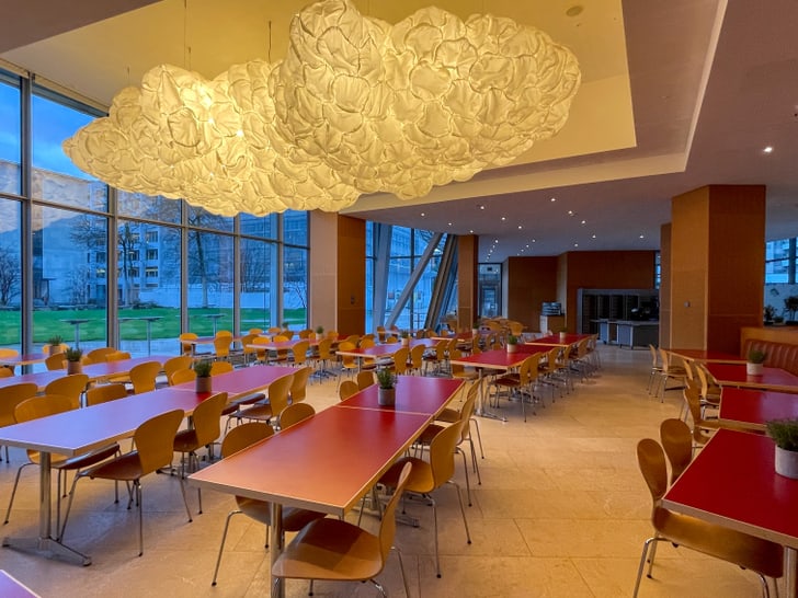 Leerer Speisesaal mit grossen Fenstern und originellen Lampen.