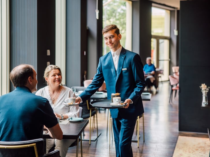 Kellner serviert Kaffee für Paar im Restaurant.