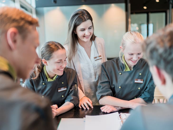 Gruppe von Lernenden in Uniform bei Besprechung