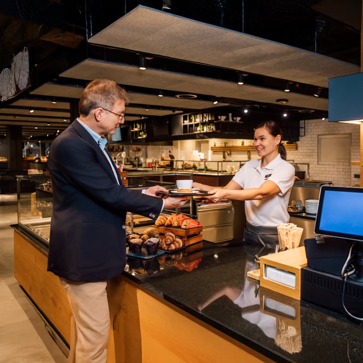 Mann erhält Kaffee von Barista in einem Café.