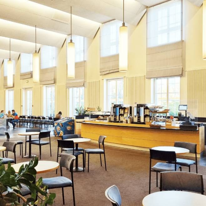 Grosser, heller Speisesaal mit Tischen und Stühlen.
