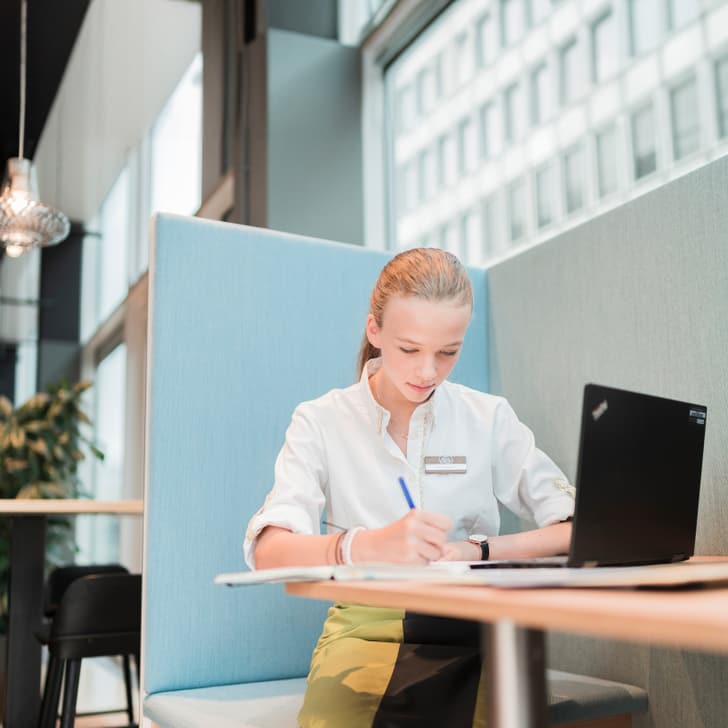 Frau arbeitet an einem Laptop in einem modernen Büro.