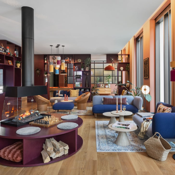 Moderne, helle Wohnzimmer mit Kamin, blauen Sofas und Holzboden.