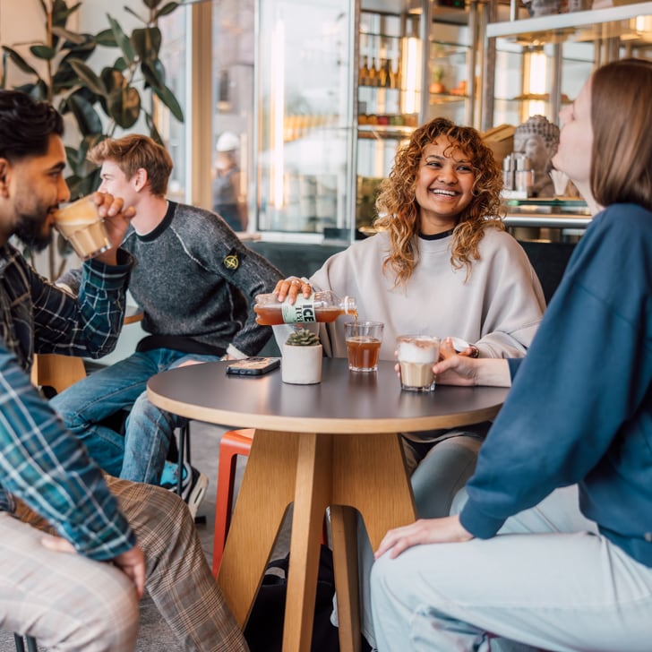 Junge Leute sitzen bei Kaffee und Gesprächen in einem Café.