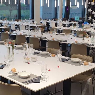 Ein grosser, festlich gedeckter Speisesaal mit Tischen und Stühlen.