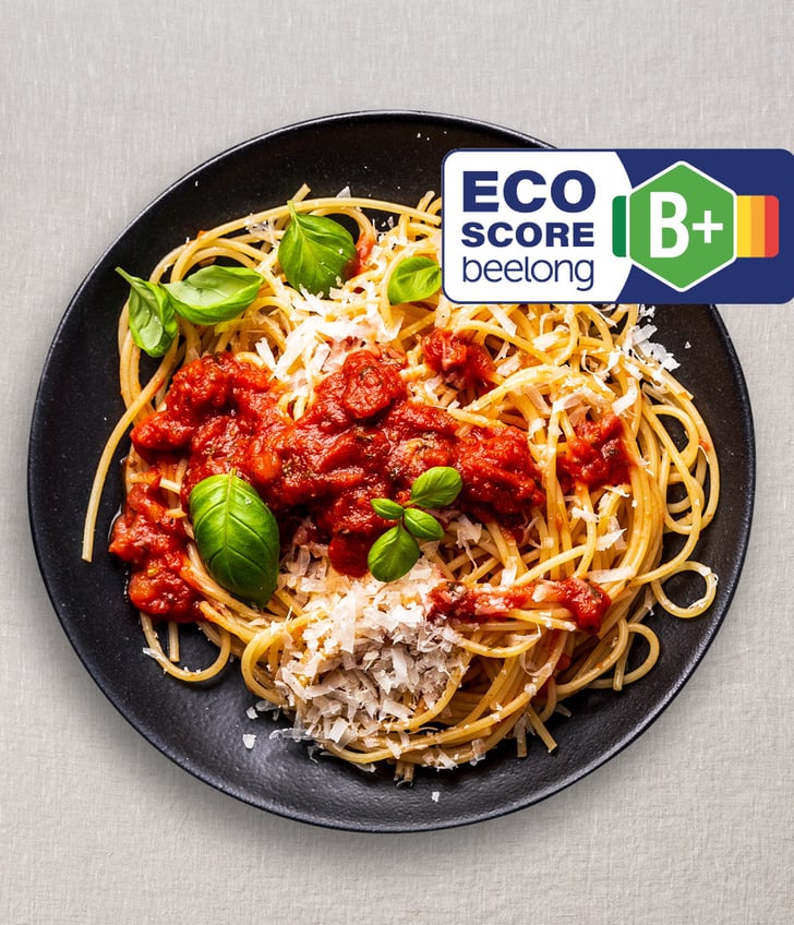 Teller mit Spaghetti und Tomatensosse, ECO-Score B+ Etikett.