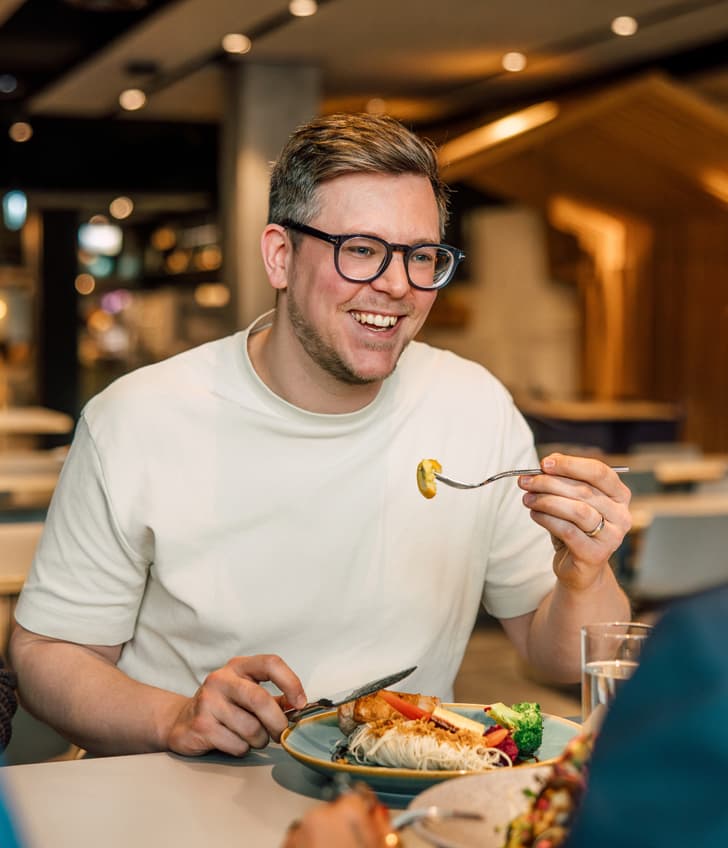 Lächelnder Mann beim Essen im Restaurant.