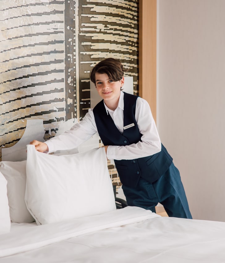 Hotelangestellter macht das Bett.