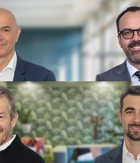 Vier Geschäftsmänner in zwei Reihen, Bürohintergrund