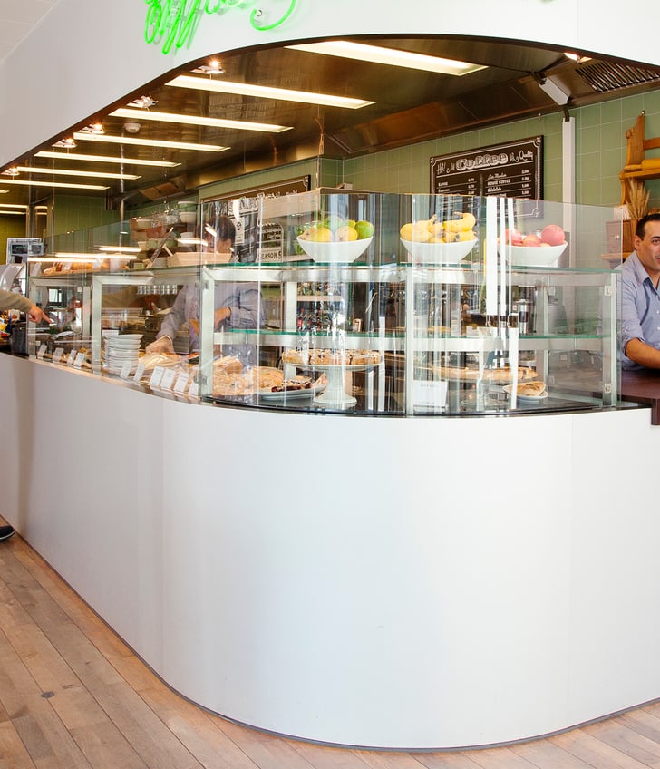 Cafeteria mit Theke und zwei Personen in Gesprächen.