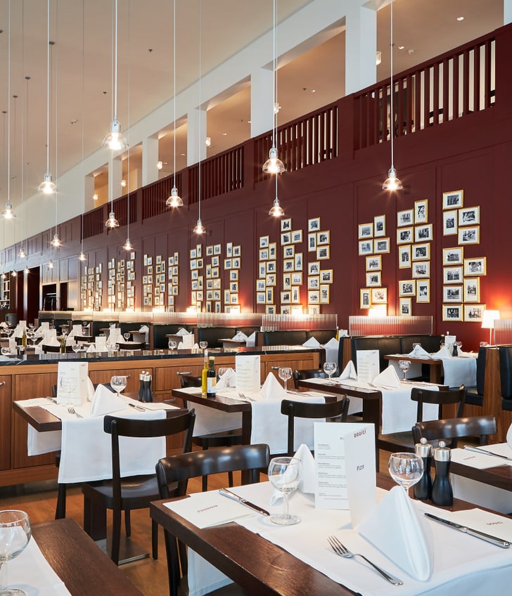 Elegantes Restaurant mit weiss gedeckten Tischen und Wandkunst.