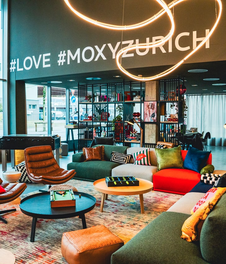 Moderne Hotellobby mit bunten Möbeln und Hashtags an der Wand.