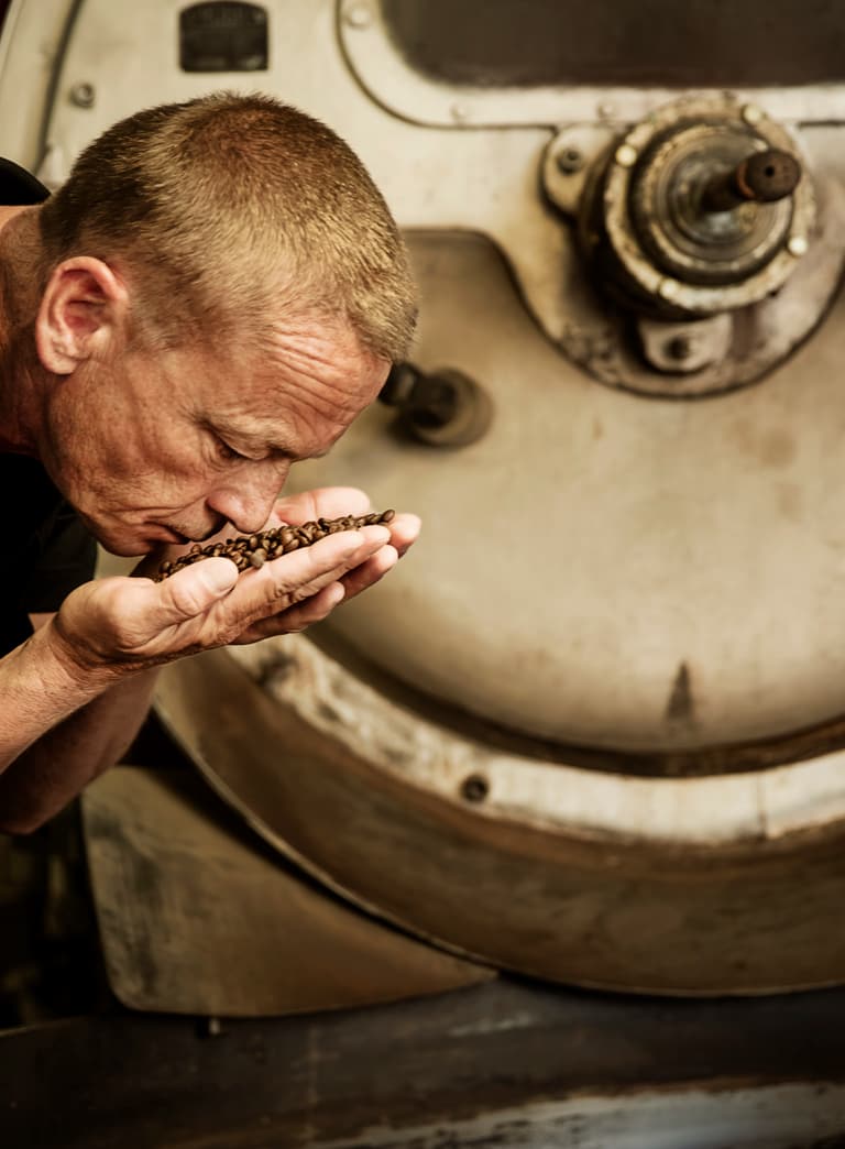 Mann, der an gerösteten Kaffeebohnen riecht.