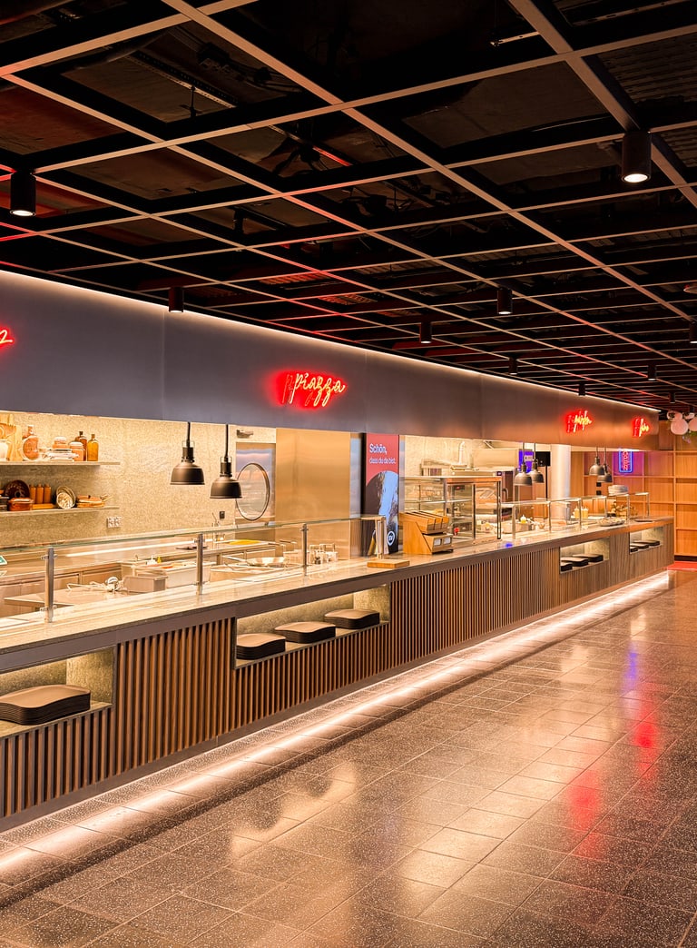 Moderne Kantine mit Buffet und Neonlichtern.