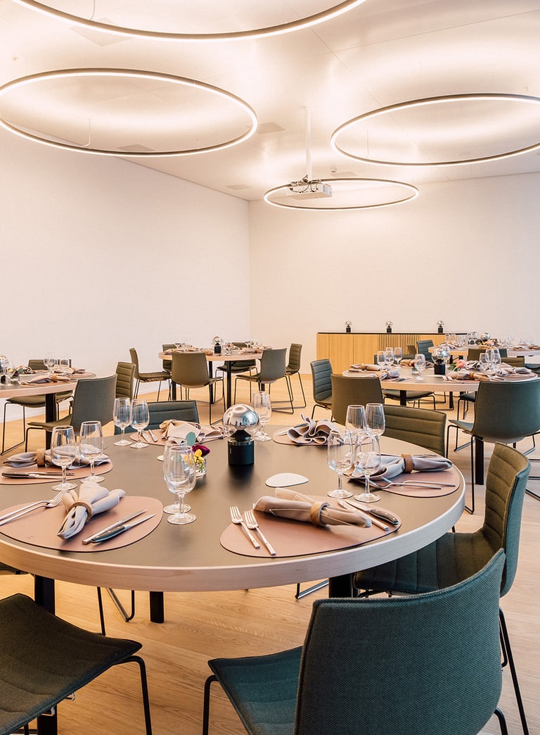 Moderner Speisesaal mit gedeckten Tischen und Stühlen.