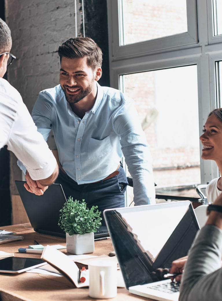 Zwei Personen schütteln sich lächelnd die Hände.