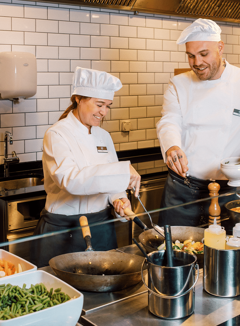 Zwei Köche kochen zusammen in einer Restaurantküche.