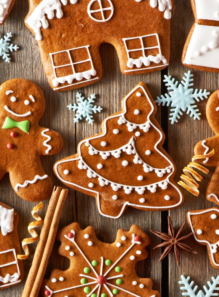 Weihnachtsplätzchen in verschiedenen Formen und Designs auf Holzuntergrund.