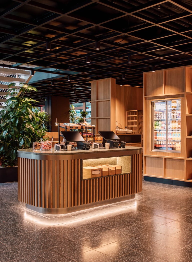 Moderne Café-Lounge mit Holztheke und Pflanzen.