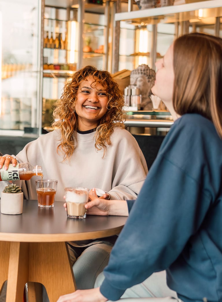 Gruppe von Menschen, die in einem Café lachen und sprechen.